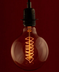 Edison G125 Globe Spiral incandescent light bulb on red Background